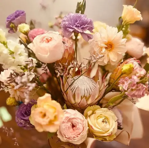 Nòa — our signature, beautifully balanced arrangement built around king protea and garden roses